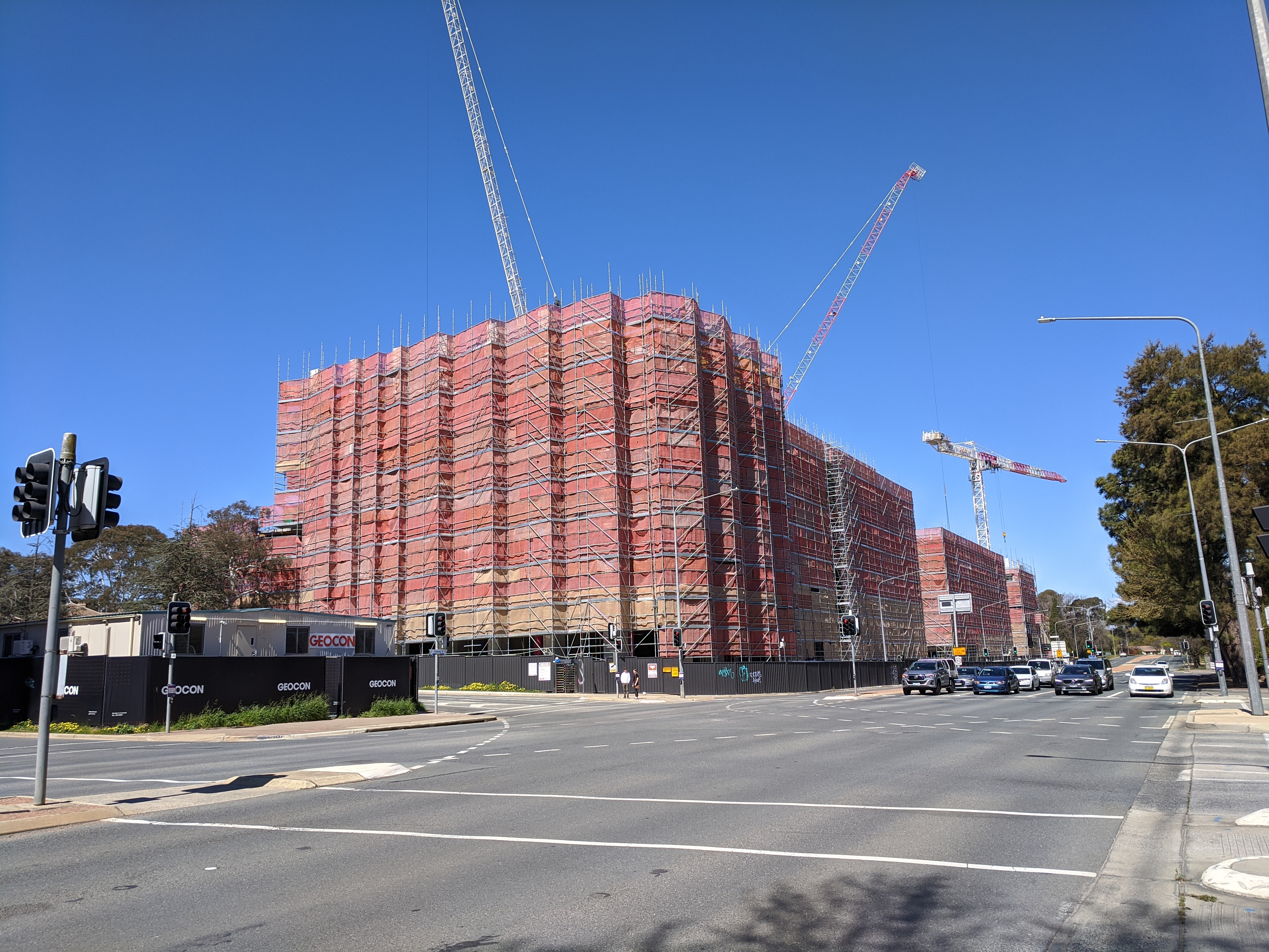 Multiple apartment buildings under construction beside an urban street