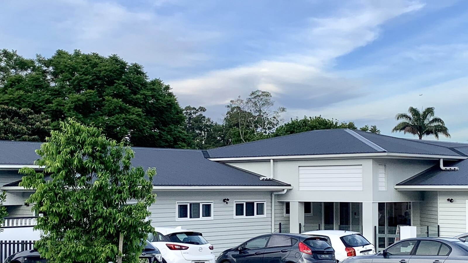 A single-storey early learning child care centre building with a low-pitched roof and parked cars in front