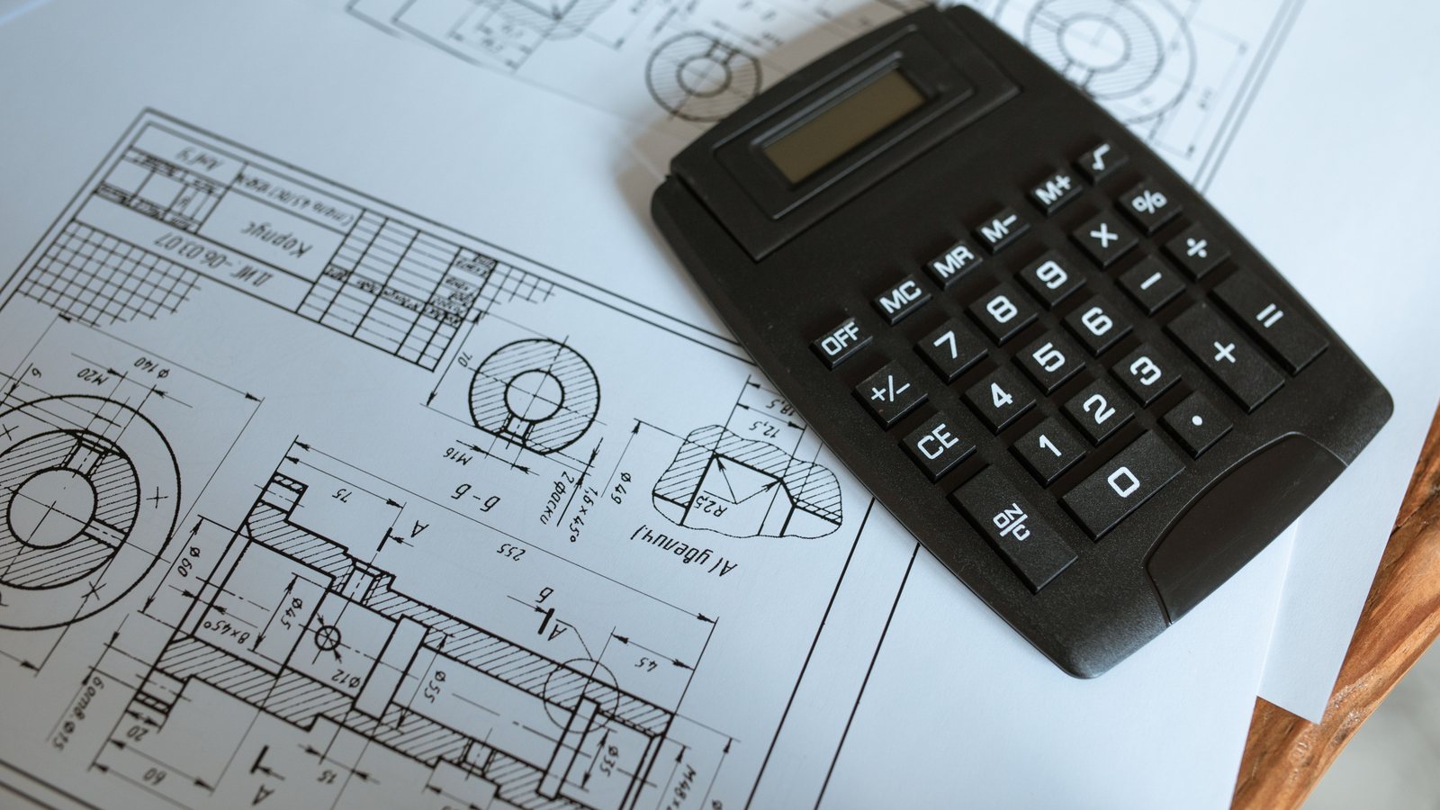 Developer calculating project cash flow beside construction plans