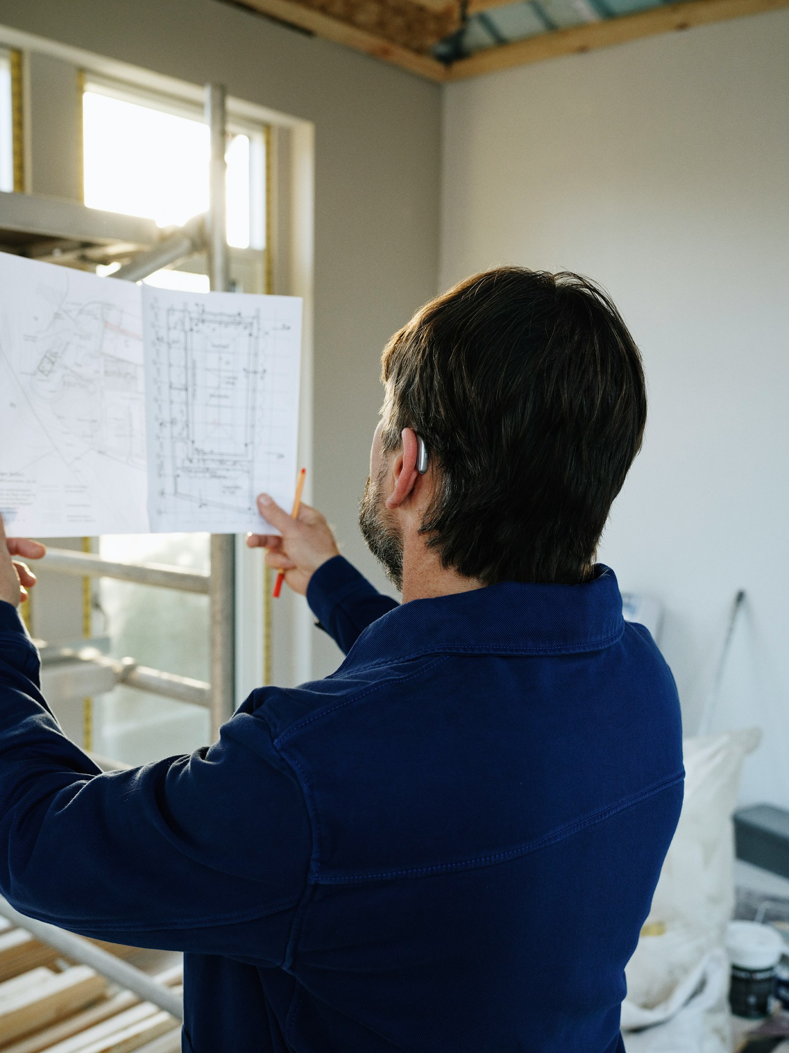 Construction professional reviewing residential building plans on site