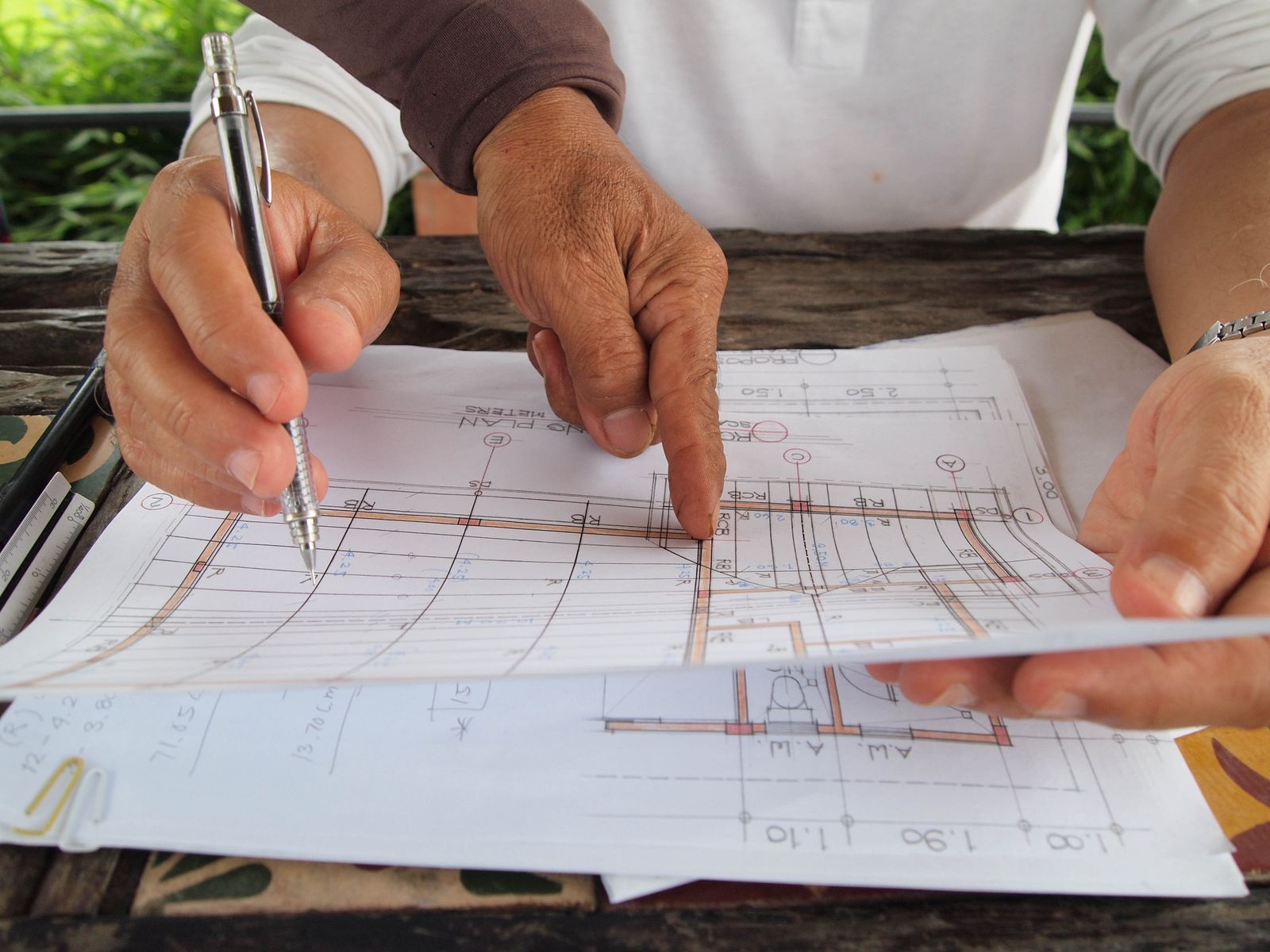Calculator and notes beside architectural blueprints