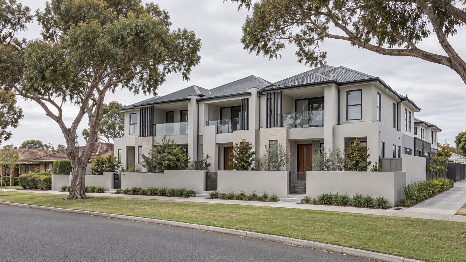 Multi-dwelling development of pale two-storey attached homes on a suburban street