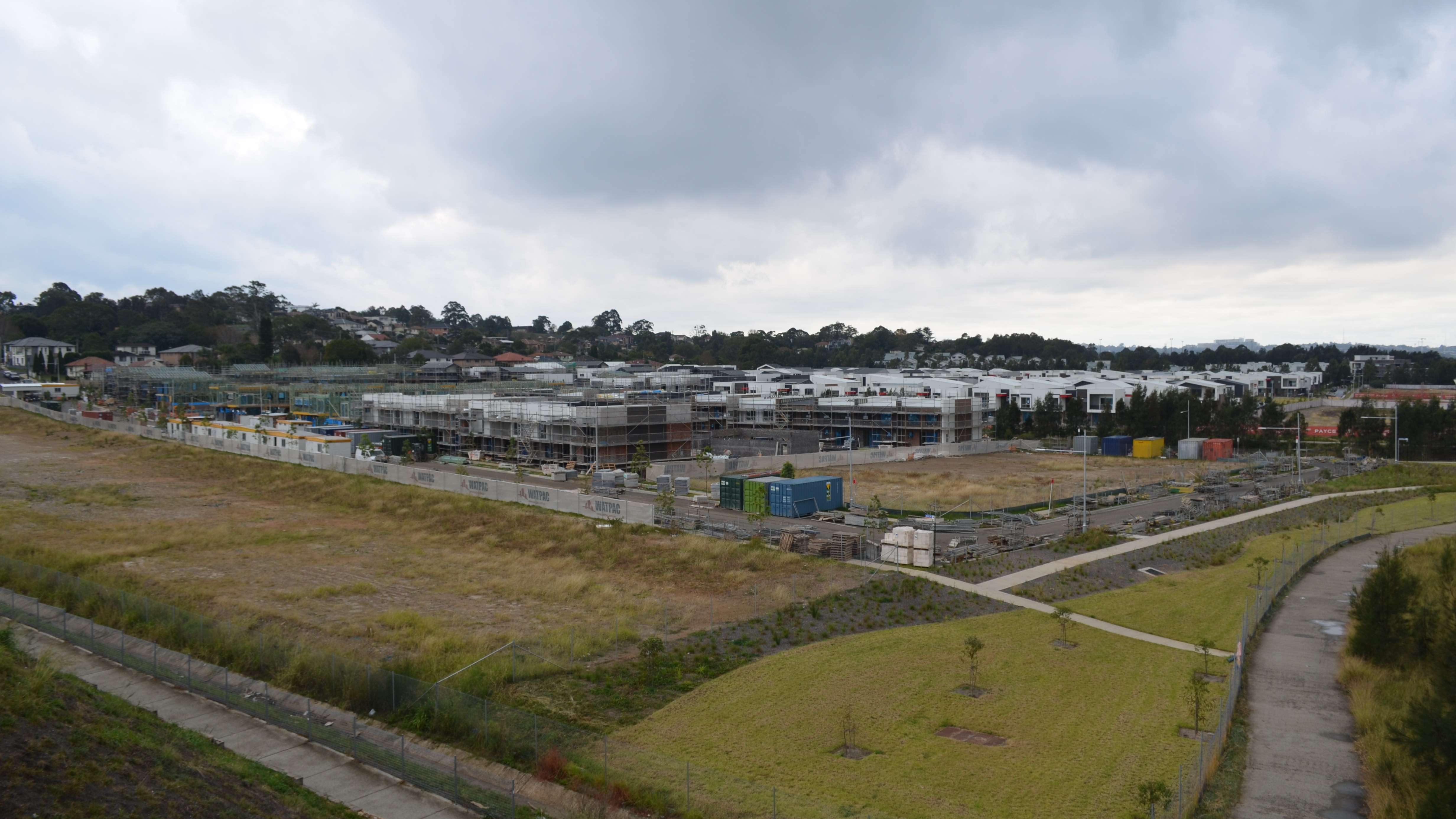 Wide view of a residential housing estate under construction in Australia with formed streets and homes in progress